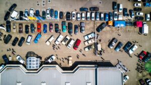 Vista aérea de zona logística con numerosos vehículos organizados en un espacio de transporte y distribución.