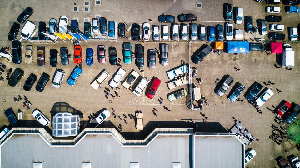 Vista aérea de zona logística con numerosos vehículos organizados en un espacio de transporte y distribución.
