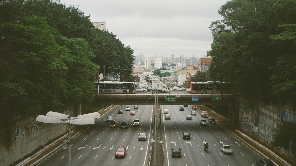 Autovía urbana con tráfico fluido y vehículos circulando por varios carriles en un entorno industrial y urbano.